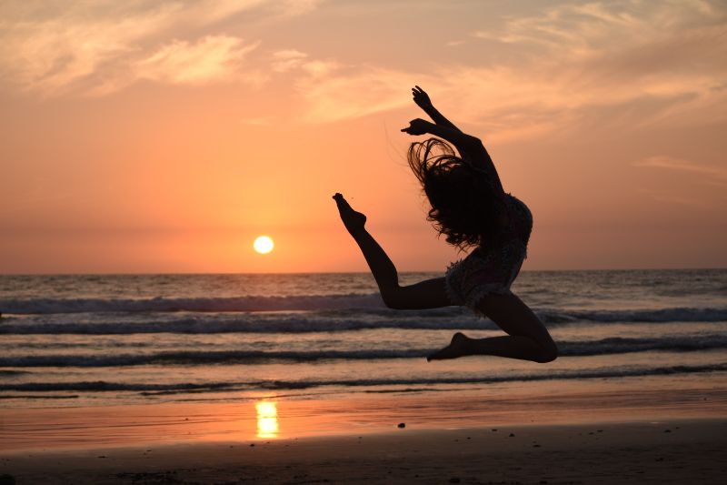 Woman jumping with sunset behind