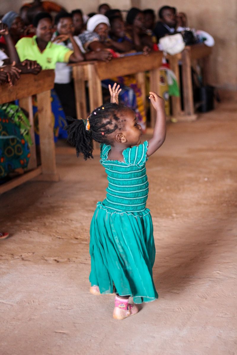 LIttle girl dancing in front of a crowd